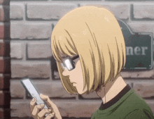 a person looking at a cell phone in front of a sign that says " ner "