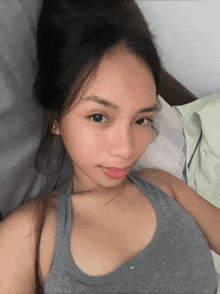 a woman laying on a bed with her hair in a bun