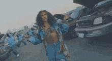 a group of people are dancing in a parking lot with their arms in the air