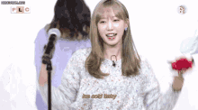 a girl is singing into a microphone while holding flowers and the words ice cold baby are next to her