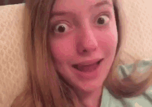 a young girl is making a funny face with her mouth open .