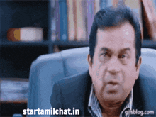 a man sitting in a chair with the website starttamilchat.in displayed