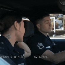 a man and a woman are sitting in a car with the time of 14:57