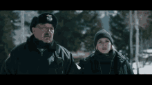 a police officer and a girl are standing in the snow looking at each other