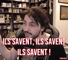 a man sitting in front of a microphone with the words ils savent ils savent