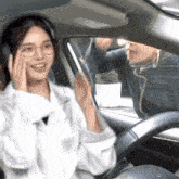 a woman wearing headphones is sitting in a car with a man behind her
