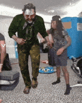a man in a mask is dancing in a room with a sign that says viggle.ai on it