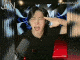 a man wearing headphones is making a salute gesture with his hand