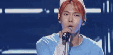 a man with red hair is singing into a microphone .