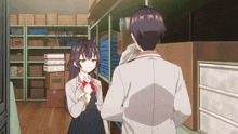 a man and a girl are standing in a room with boxes on the shelves and the girl is wearing a red bow tie
