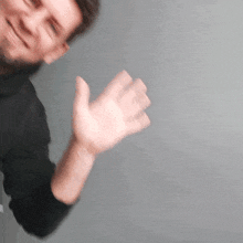 a blurry picture of a man 's hand against a grey background