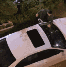 a man standing on top of a white car