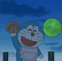 a cartoon character named doraemon is holding a cookie and a green ball
