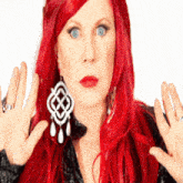 a woman with red hair wearing a pair of earrings