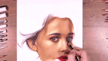 a person is drawing a woman 's face with a marker and colored pencils
