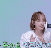 a woman wearing ear buds and a white shirt with foreign writing
