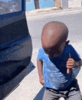 a baby with a very large head is holding a knife