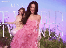 a woman in a pink dress is standing in front of a sign that says ' lingormgifs ' on it