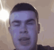 a man is making a funny face with his eyes closed and his mouth open .