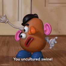 a mr potato head says " you uncultured swine " on a wooden floor