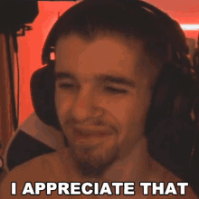 a shirtless man wearing headphones is making a funny face and saying i appreciate that .