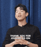 a young man wearing a black sweater and a microphone is talking to someone .