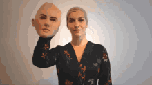 a woman is holding a mask of her face