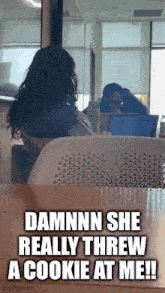 a woman sits at a table with a laptop and says " damnnn she really threw a cookie at me "