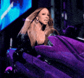 a woman is sitting in a purple car with a glowing screen behind her