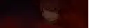 a close up of a person wearing a mask in a dark room with a red background .
