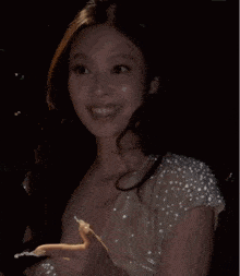 a woman in a white dress with pearls on the sleeves