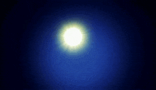 a hand is reaching out towards the sun in a dark blue sky