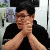 a man wearing glasses and a black shirt that says ' asiastic ' on it