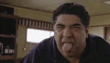 a close up of a man sticking his tongue out in a kitchen .