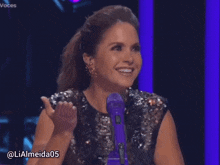 a woman sitting in front of a purple microphone with the hashtag lialmeida05 on the bottom