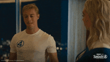 a man wearing a white shirt with the number 4 on it stands next to a woman