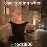 a woman in a black dress is dancing in front of a building with the words that feeling when rodri800 below her