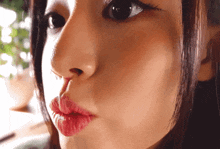 a close up of a woman 's face with red lips and black eyes