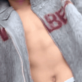 a man without a shirt is wearing a jacket with the letter b painted on it