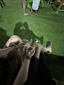a man wearing a watch is sitting on a woman 's lap giving the peace sign