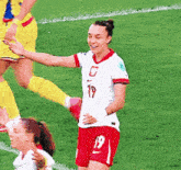 a female soccer player wearing a white jersey with the number 19 on it