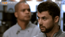 two men are standing in front of a sign that says top chef on it