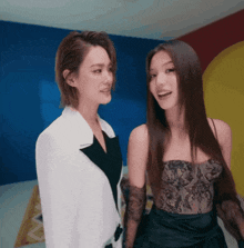 two women are standing next to each other and one is wearing a black lace top