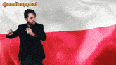 a man in a suit stands in front of a red and white flag with the hashtag @emileappeal