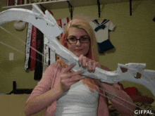 a woman holding a bow and arrow with a gifpal watermark on the bottom
