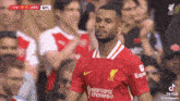 a soccer player wearing a red jersey with the word chartered on it