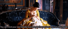 a woman in a yellow dress is sitting on a couch with the words you can mind your own bloody business