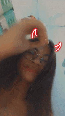 a girl wearing glasses and devil horns is taking a selfie
