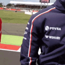 a man wearing a blue jacket with pdvsa and wihiuri written on it