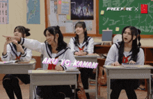 a group of girls are sitting at desks in a classroom with aku yg kanan written on the wall behind them